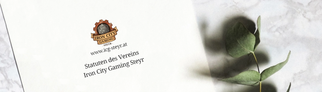Die Statuten des Vereins Iron City Gaming Steyr liegen in gedruckter Version auf einem Marmortisch mit einem Eukalyptus-Ast als Deko.