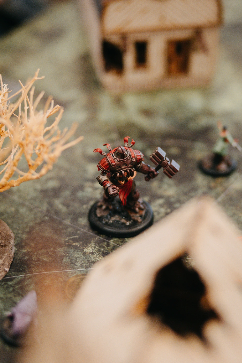 Rot bemalte Warhammer-Miniatur auf einem Tabletop-Spielgelände.