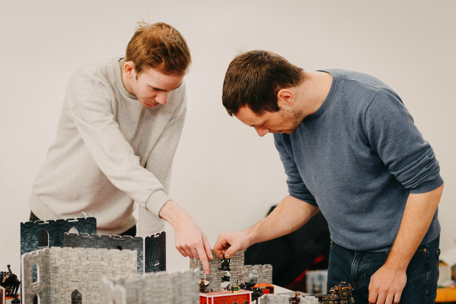 Zwei Personen stehen um einen Tisch und spielen Warhammer.