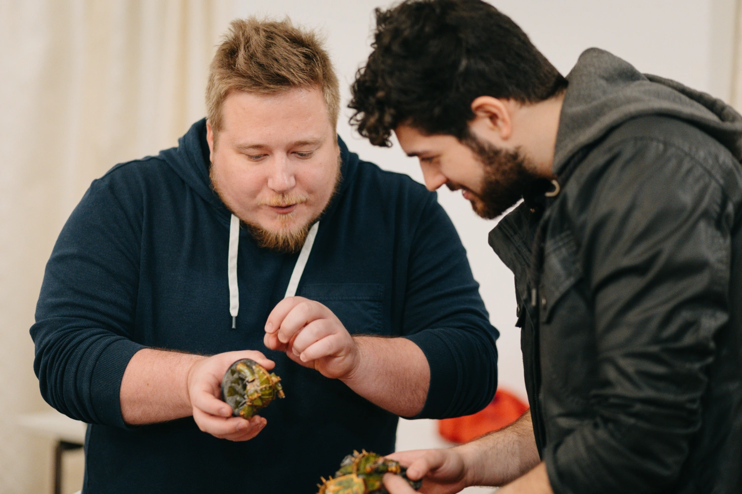 Ein Spieler zeigt einem anderen Spieler seine Warhammer-Miniatur.